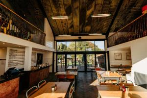 a restaurant with wooden ceilings and tables and chairs at Creeksea Place Barns in Burnham on Crouch