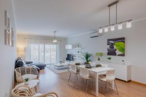 Una cocina y una sala de estar con mesa y sillas. en Apartamento 7 Mares com Suite, en Sagres