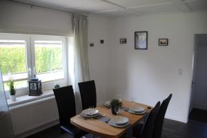 comedor con mesa, sillas y ventana en Haus Sperling en Bad Zwischenahn