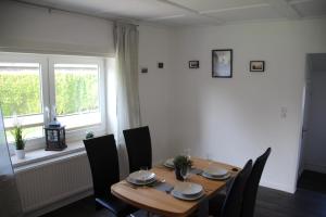 a dining room with a table and chairs and a window at Haus Sperling in Bad Zwischenahn