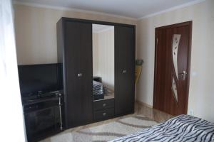 a bedroom with a large black cabinet with a mirror at ЗАТИШОК in Sinyak