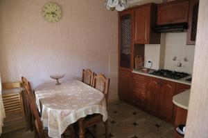a kitchen with a table and chairs and a clock on the wall at ЗАТИШОК in Sinyak
