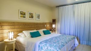 a bedroom with a large bed with blue pillows at Kanaloa Pousada in Jericoacoara