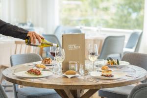 普拉加德阿罗Park Hotel San Jorge & Spa by Escampa Hotels的把酒倒进餐桌上,放上盘子