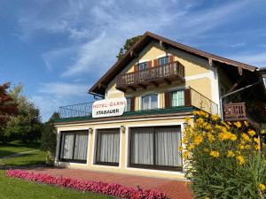 ein Gebäude mit einem Balkon und Blumen davor in der Unterkunft Hotel - Garni Stabauer in Mondsee