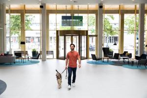 a man walking a dog in a lobby at Holiday Inn Express Amsterdam - North Riverside by IHG in Amsterdam
