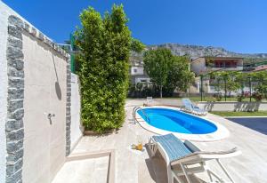 a swimming pool with two chairs and a swimming pool at Villa Živana in Dugi Rat