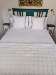 a white bed with white pillows and a green headboard at Micro Barn Barnard Castle The Crown pub is open Fri to Sun check Facebook for hours in Mickleton