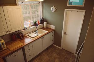 a small kitchen with a sink and a window at Penygelli Apartments in Newtown +37 photos