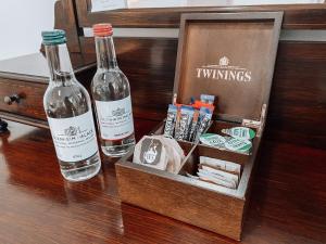 The Blenheim Buttery في وودستوك: زجاجتان من النبيذ تقعان على طاولة مع صندوق