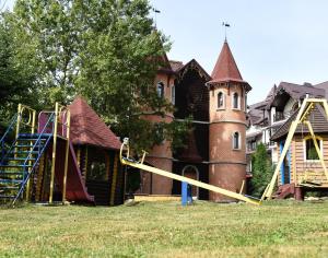 una casa antigua con parque infantil y castillo en Castle Belvedere, en Bukovel