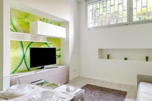 sala de estar blanca con TV y ventana en Modernissimo Loft in Porta Romana, a 200m dalla Bocconi, en Milán