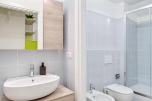 ミラノにあるModernissimo Loft in Porta Romana, a 200m dalla Bocconiの洗面台、トイレ、鏡のあるバスルーム +7枚の写真