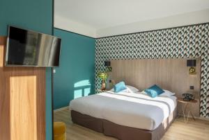 a bedroom with a bed and a television at Hôtel Le Bristol in Avignon