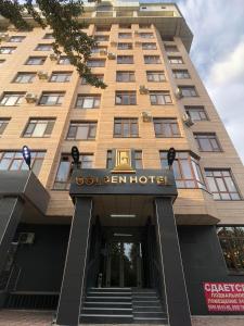 un edificio con un cartel de hotel en Golden Hotel en Bishkek