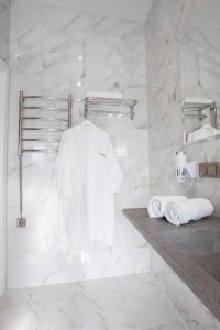 a white bathroom with a sink and towels on a counter at Kulikovskiy hotel in Kharkiv