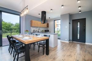 Una cocina y un comedor con mesa y sillas de madera. en Fort Północny, en Jastrzębia Góra