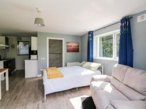 uma sala de estar com uma cama e um sofá em SeaChange Annexe em Ballygarrett