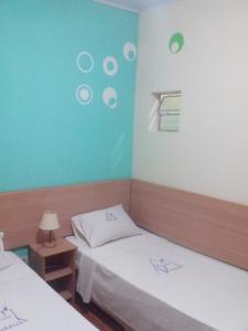 Una habitación con dos camas y una pared azul. en Hotel Pousada Viana, en São Paulo 17 fotos más