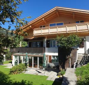 Casa grande con balcón y césped en Casa Berger, en Davos