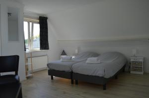- une chambre avec un lit et 2 oreillers dans l'établissement t Laege Uus, à Burgh-Haamstede