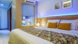 a bedroom with a large bed and a window at Kanaloa Pousada in Jericoacoara