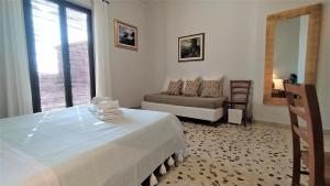 ein Schlafzimmer mit einem Bett, einem Sofa und einem Spiegel in der Unterkunft Casa Aranci in Acireale