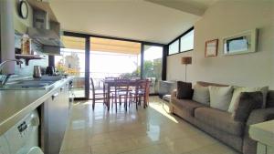 eine Küche und ein Wohnzimmer mit einem Sofa und einem Tisch in der Unterkunft Casa Aranci in Acireale