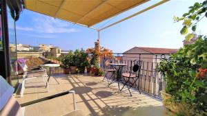 eine Terrasse mit einem Tisch und Stühlen auf dem Balkon in der Unterkunft Casa Aranci in Acireale