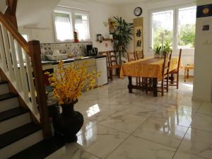 cocina y comedor con mesa y jarrón con flores en Villa Sunshine en Bagneux