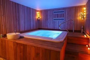 a bathroom with a bath tub with a sink at Le Miel des Muses in Brive-la-Gaillarde