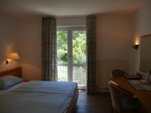 a bedroom with a bed and a large window at Landgasthof Adler in Künzelsau