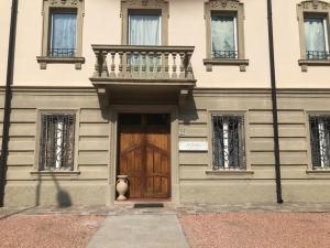 a building with a wooden door and a balcony at La Sosta camere & appartamenti in San Felice sul Panaro