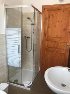 uma casa de banho com um chuveiro, um lavatório e um WC. em La Sosta camere & appartamenti em San Felice sul Panaro