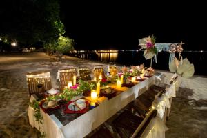 a long table with candles on the beach at night at Sao Biển Cam Ranh - Starfish Cam Ranh in Cam Ranh +151 photos
