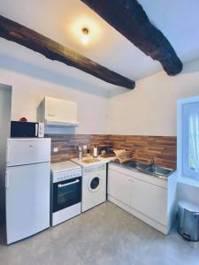 uma cozinha com electrodomésticos brancos e um lavatório em Le Cosy B em La Gouesnière