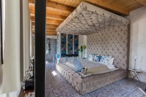 a large bed in a room with a stone wall at Diodorus Luxury Experience in Favara