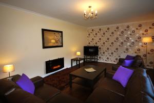 a living room with a couch and a fireplace at Clover Holidays - Cliff View in Perth