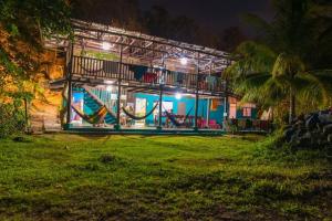 a building with a hammock in a park at night at Luminosa Montezuma Hostel in Montezuma