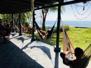 um grupo de pessoas relaxando em redes na praia em Luminosa Montezuma Hostel em Montezuma