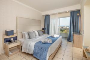 a bedroom with a large bed and a large window at Athineon Hotel in Rhodes Town