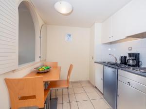 a kitchen with a table with a bowl of fruit on it at Athineon Hotel in Rhodes Town
