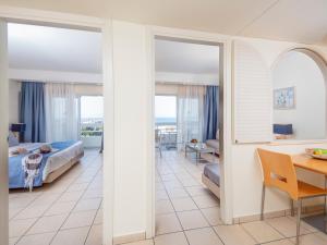 a living room with a bed and a dining room at Athineon Hotel in Rhodes Town