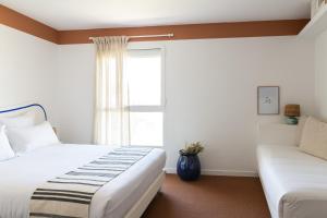 a bedroom with two beds and a window at Hôtel Le Sud in Juan-les-Pins