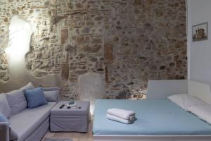 een kamer met een bank en een stenen muur bij Civico 87 in Benevento