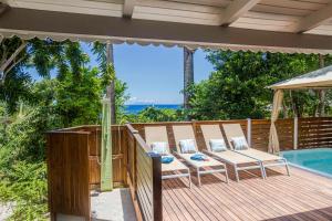 una terraza con 2 sillas y una piscina en GREEN HOUSE en Deshaies