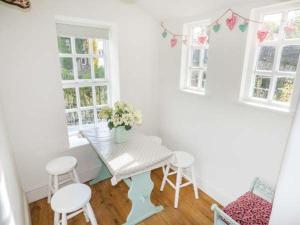 a dining room with a table and two stools at Bridge End Cottage in Carnforth