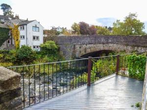 a bridge over a river with a stone tunnel at Bridge End Cottage in Carnforth