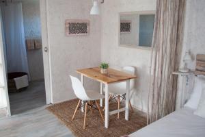 Habitación pequeña con mesa de madera y 2 sillas en Brakvlei, en Albertinia