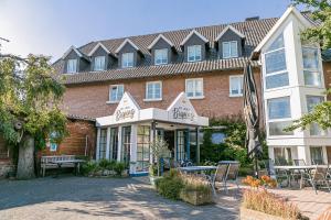 a hotel with tables and chairs in front of a building at Landhaus Bisping in Everswinkel